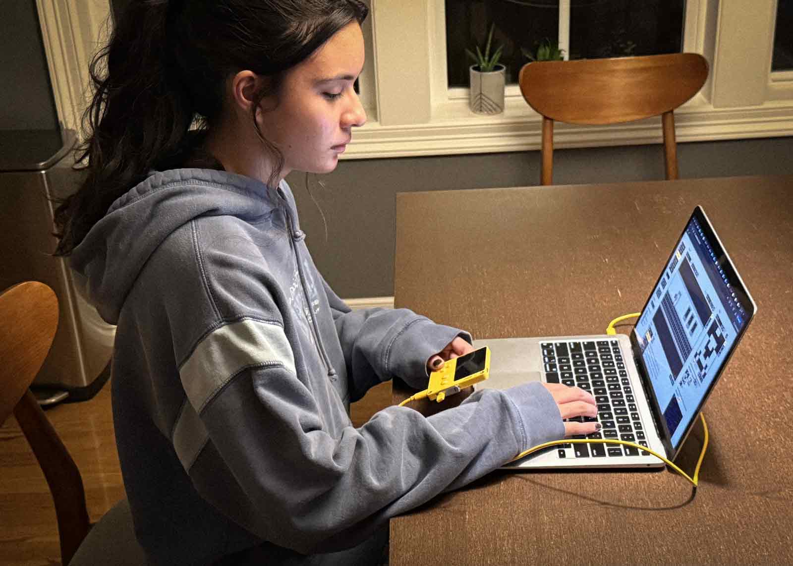 Student programming Playdate with a laptop.