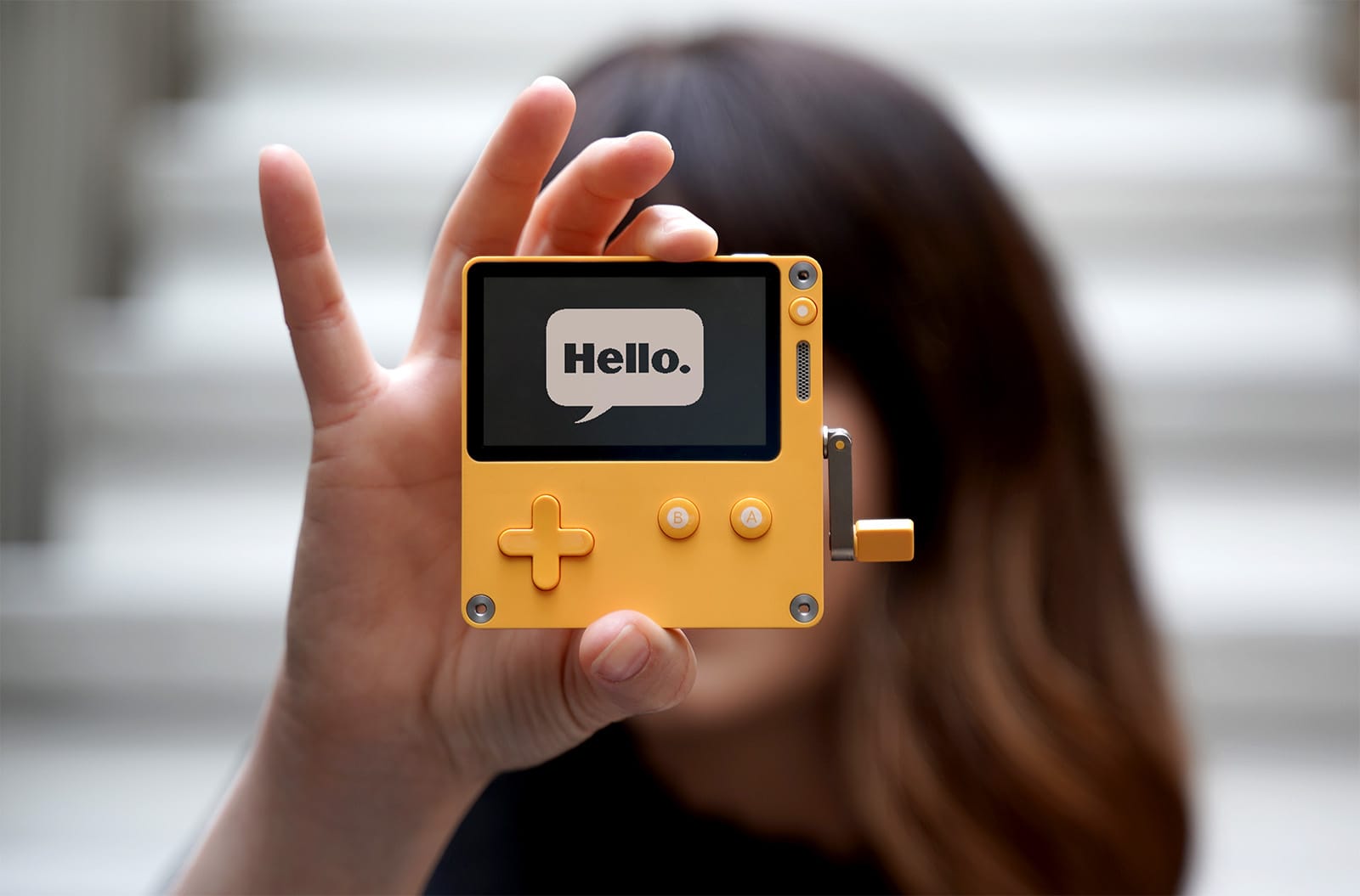 Person holding up a Playdate